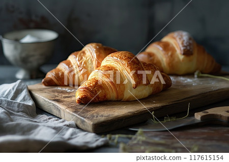 Freshly baked croissants on a wooden board, selective focus 117615154