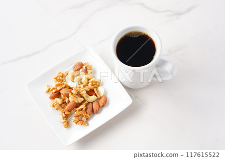 Nutritious mixed nuts and freshly brewed, aromatic coffee Nutritious mixed nuts and freshly brewed, aromatic coffee 117615522