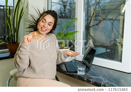 Pregnant Woman Taking Vitamins at Home 117615865