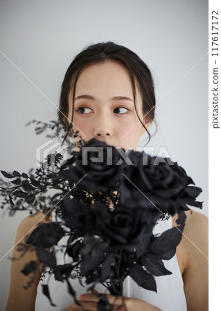 Woman holding a bouquet of black roses 117617172