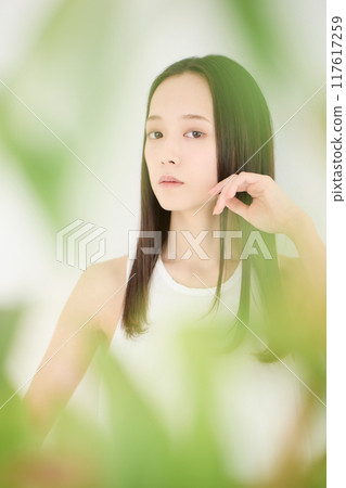 Portrait of a beautiful woman, blurred green background 117617259