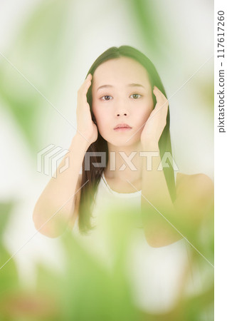 Portrait of a beautiful woman, blurred green background 117617260
