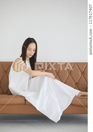 一個女人坐在沙發上做皮膚護理 一個女人坐在沙發上做皮膚護理 117617407