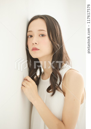 Beauty image of a woman leaning against a wall 117617576