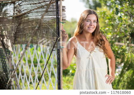 Young woman posing in cottage garden Young woman posing in cottage garden 117618060
