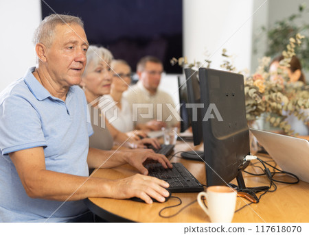 Elderly man studying at computer course in group Elderly man studying at computer course in group 117618070
