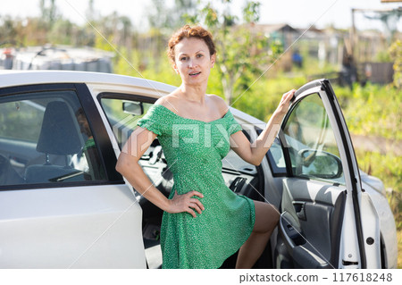 European girl has arrived in village, comes out of car 117618248