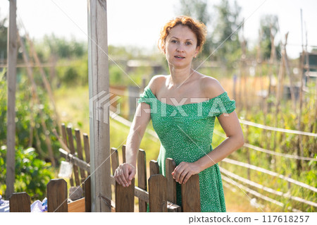 Adult woman posing in garden Adult woman posing in garden 117618257