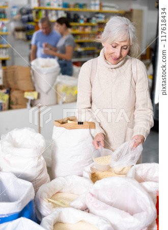 Old woman purchaser buying rice in big supermarket Old woman purchaser buying rice in big supermarket 117618434