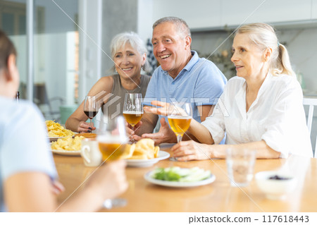 Elderly people drinking and chatting at table 117618443