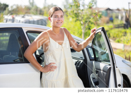 Young woman posing by car in garden 117618476