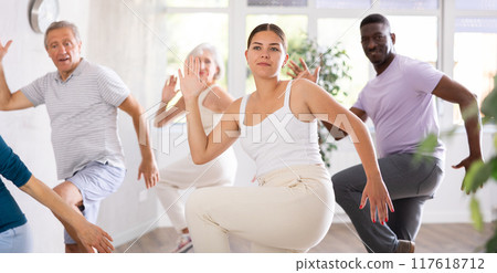 Young girl dance instructor conducting class for adults Young girl dance instructor conducting class for adults 117618712