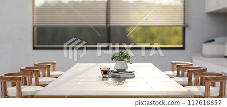 A close-up image of a minimal dining table with wooden stools in a modern kitchen. 117618857