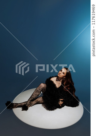 A woman is sitting on the floor with her legs crossed and her arms crossed A woman is sitting on the floor with her legs crossed and her arms crossed 117619469