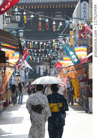 Kawasaki Daishi: A woman in a yukata walking down Nakamise Street in the Furin Market [Kanagawa Prefecture, Kawasaki City, Kawasaki Ward] 117620494