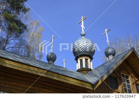 Fragment of wooden Orthodox Christian Church with dome and cross in the forest in Siberia in spring 117620947
