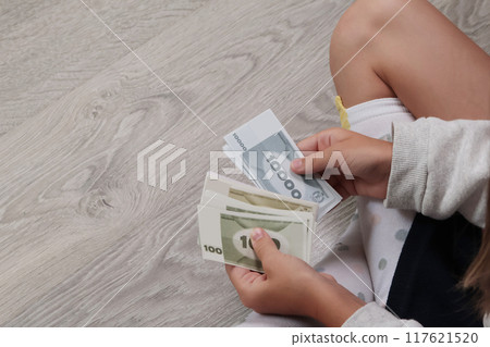 Schoolgirl hold bills in hands and count them. Money, business and finance. Game for children. Schoolgirl hold bills in hands and count them. Money, business and finance. Game for children. 117621520