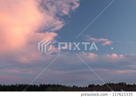 Pink and blue sunset over forest and village. Romantic dramatic background for design. Sky and clouds. Pink and blue sunset over forest and village. Romantic dramatic background for design. Sky and clouds. 117621535