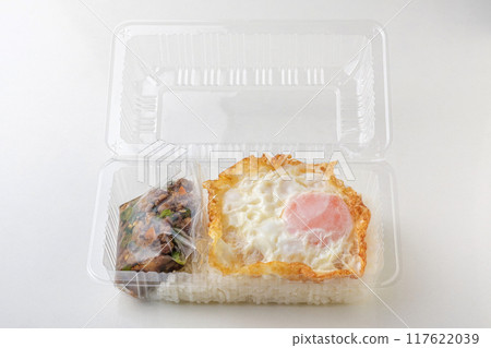 Stir-fried minced pork with basil and fried egg on rice packed in a clear plastic box takeaway food concept on white background Stir-fried minced pork with basil and fried egg on rice packed in a clear plastic box takeaway food concept on white background 117622039