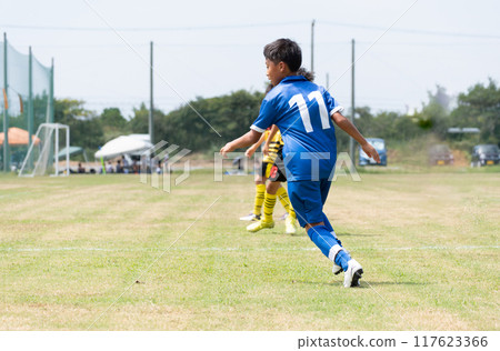 Elementary school boy playing soccer match 117623366