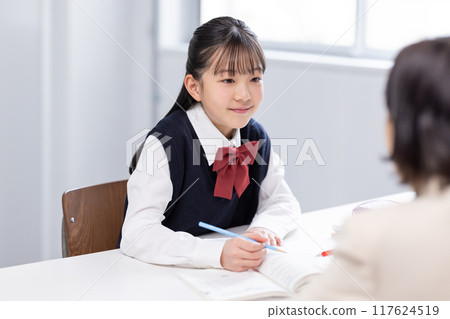 Female junior high school student studying with teacher at cram school 117624519