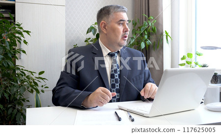 Tired Businessman in Suit Looking Out the Window 117625005
