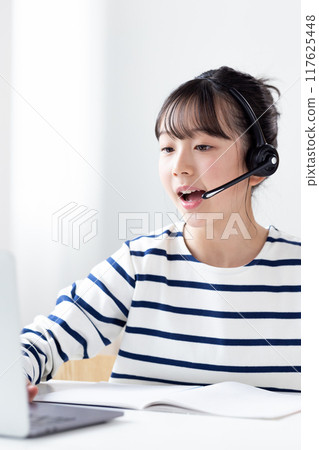 一個女孩在筆記型電腦上上網課 117625448