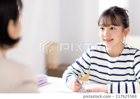 一個女孩在補習班和她的老師一起學習 117625568