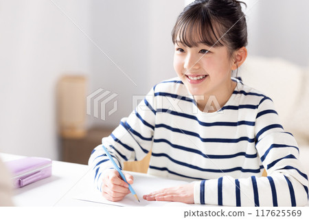 A girl studying with her teacher at a cram school 117625569