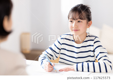 一個女孩在補習班和她的老師一起學習 一個女孩在補習班和她的老師一起學習 117625573