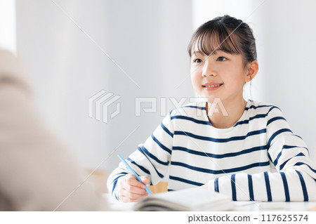 A girl studying with her teacher at a cram school 117625574