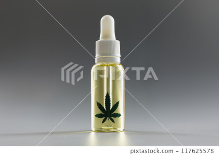 Hemp oil with a dropper on a gray background, close-up Hemp oil with a dropper on a gray background, close-up 117625578