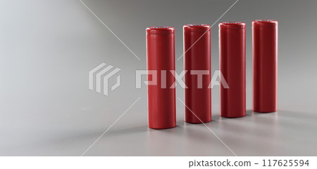 Red alloy batteries stand in a row on a gray background 117625594