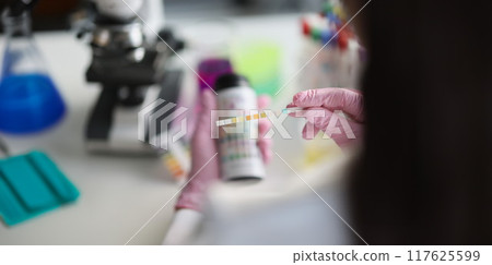 Hands in the laboratory hold a litmus test strip 117625599