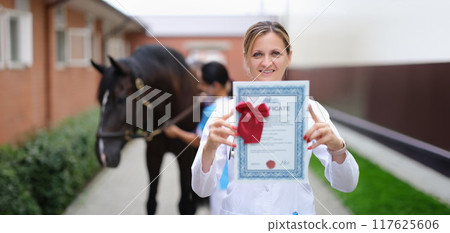 Happy woman vet doctor holding a horse certificate 117625606