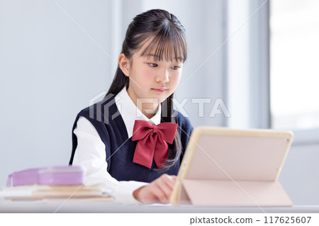 Female junior high school student studying on a tablet Female junior high school student studying on a tablet 117625607