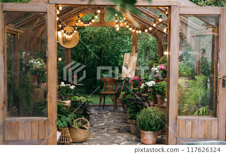 Wood and glass greenhouse, plants and nature with home gardening. Flowers and greens, with botanical or agriculture in the garden. exterior Wood and glass greenhouse, plants and nature with home gardening. Flowers and greens, with botanical or agriculture in the garden. exterior 117626324