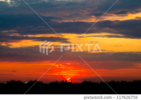 Sunset Sun in the Clouds over the City Rooftops Sunset Sun in the Clouds over the City Rooftops 117626756