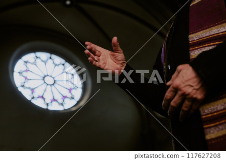 Low angle shot of unrecognizable wrinkled hands of priest during service in church Low angle shot of unrecognizable wrinkled hands of priest during service in church 117627208