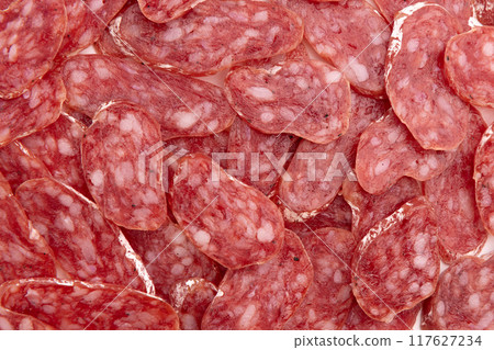 heap of salami sausage, slices of salami as background 117627234
