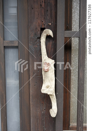 Tsumago-juku: Old streetscape of traditional houses, with a wooden carved monkey displayed in front of the entrance 117627386