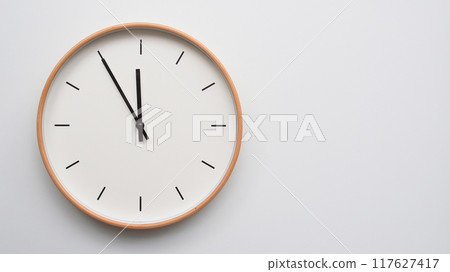 Minimalist wooden Wall Clock on White Wooden Surface with Space for Text. Time Set at 23.55/11.55 Minimalist wooden Wall Clock on White Wooden Surface with Space for Text. Time Set at 23.55/11.55 117627417