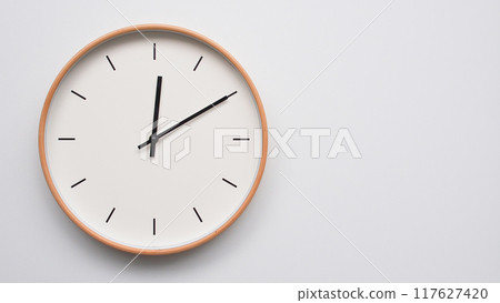 Minimalist wooden Wall Clock on White Wooden Surface with Space for Text. Time Set at 12.10/00.10 117627420