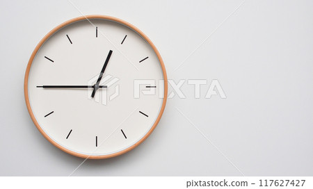 Minimalist wooden Wall Clock on White Wooden Surface with Space for Text. Time Set at 00.45/12.45 117627427