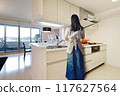 A woman cooks in an island kitchen in a high-rise apartment 117627564