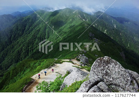 Three people enjoying summer alpine climbing 117627744