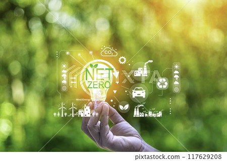 net zero concept. Hand holding with net zero icon on blur green leaf. carbon neutral and green natural background on with clean energy icon around it. Carbon gas affects global warming. net zero concept. Hand holding with net zero icon on blur green leaf. carbon neutral and green natural background on with clean energy icon around it. Carbon gas affects global warming. 117629208