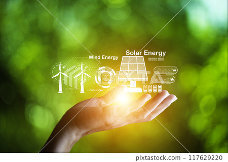 Hand holding with  green energy, wind energy, solar energy icon on blur green leaf. carbon neutral and green natural background  with energy icon around it. Carbon gas affects global warming. 117629220