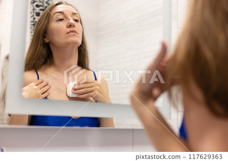 Woman applying cream from stick to smooth out wrinkles on her neckline or like sun protection cream stick. Woman applying cream from stick to smooth out wrinkles on her neckline or like sun protection cream stick. 117629363