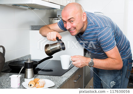 Ordinary man preparing coffee in moka pot in the kitchen 117630056
